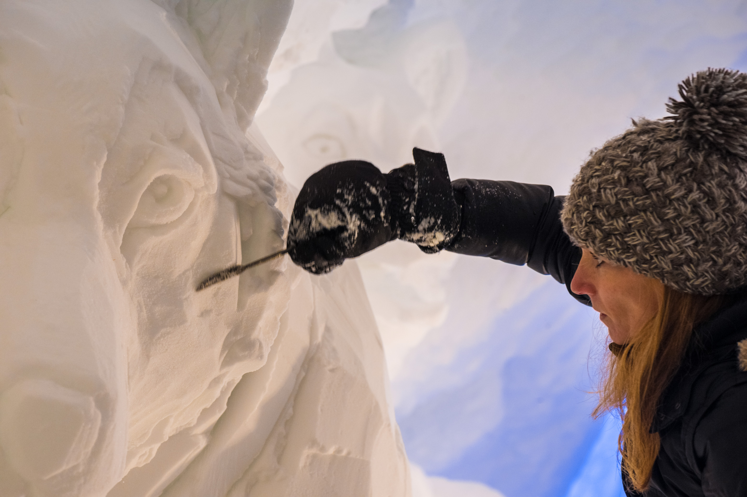 France, Auvergne-Rhône-Alpes, vallée de la Tarentaise, massif de la Vanoise, station de sports d'hiver Arcs 2000, Camille BERNARD-DUBOIS sculpte un chien de traîneau dans la neige de la paroi du tunnel de la galerie de sculptures du village-igloo, lors de la saison hivernale 2017-2018 // France, Auvergne-Rhône-Alpes, Tarentaise valley, Vanoise massif, Arcs 2000 ski resort, Camille BERNARD-DUBOIS sculpts a sled dog in the snow of the tunnel wall of the gallery with sculptures of igloo-village, during the winter season 2017-2018